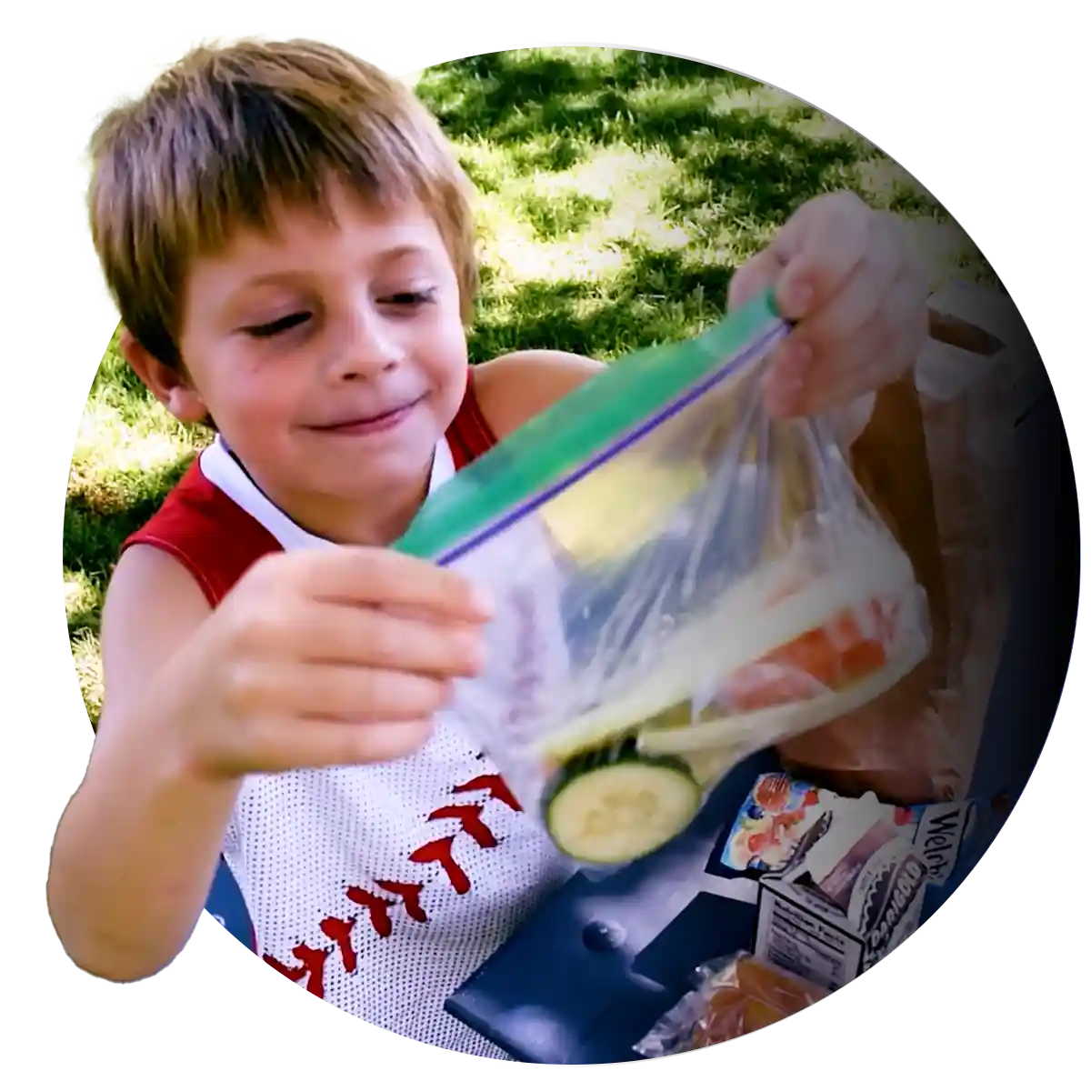 A happy boy holding food from his lunch