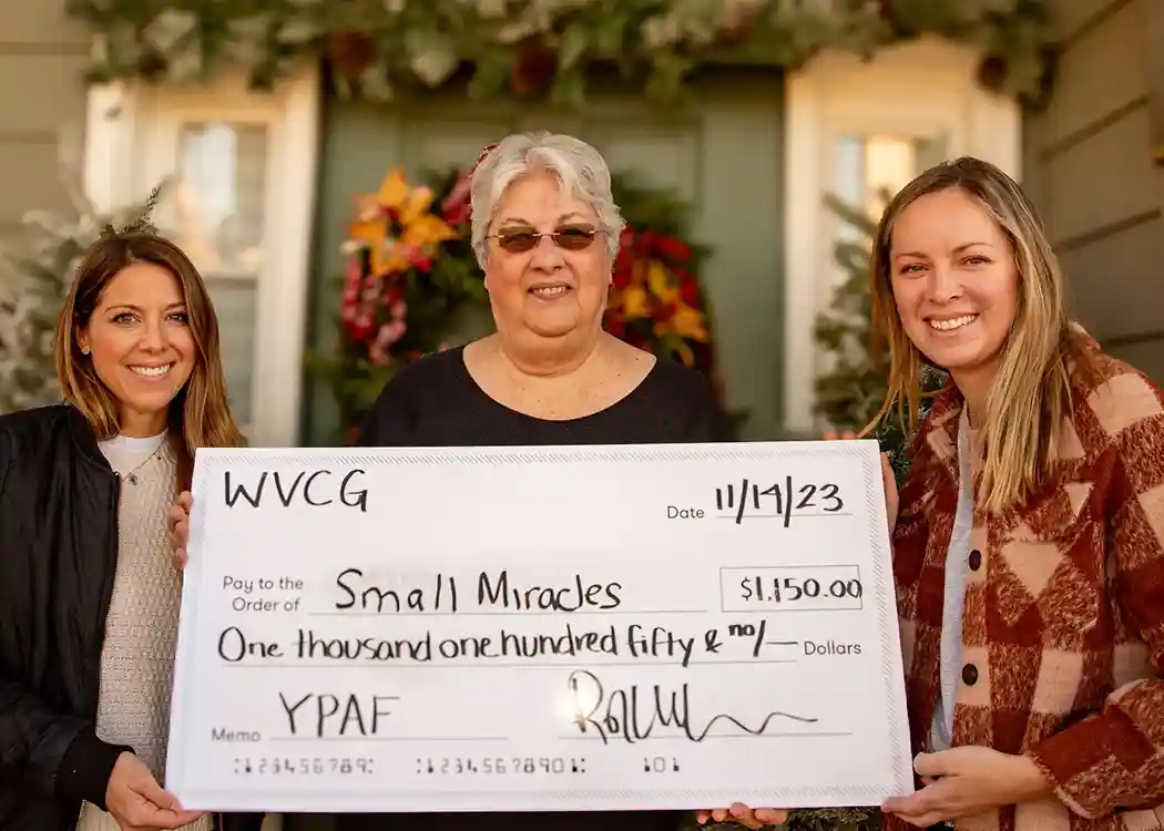 Three women holding an oversize check